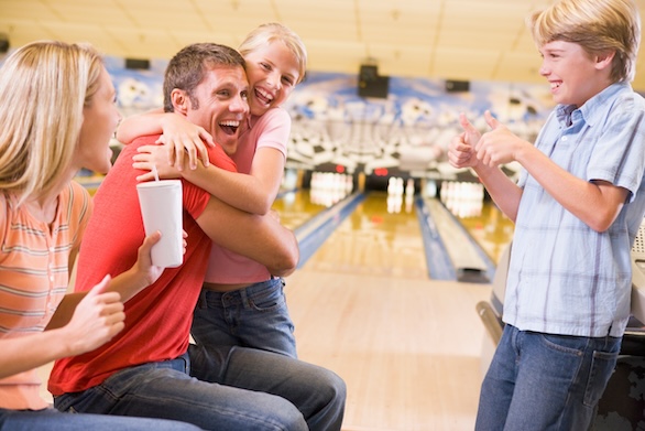 family laughing at bowling alley